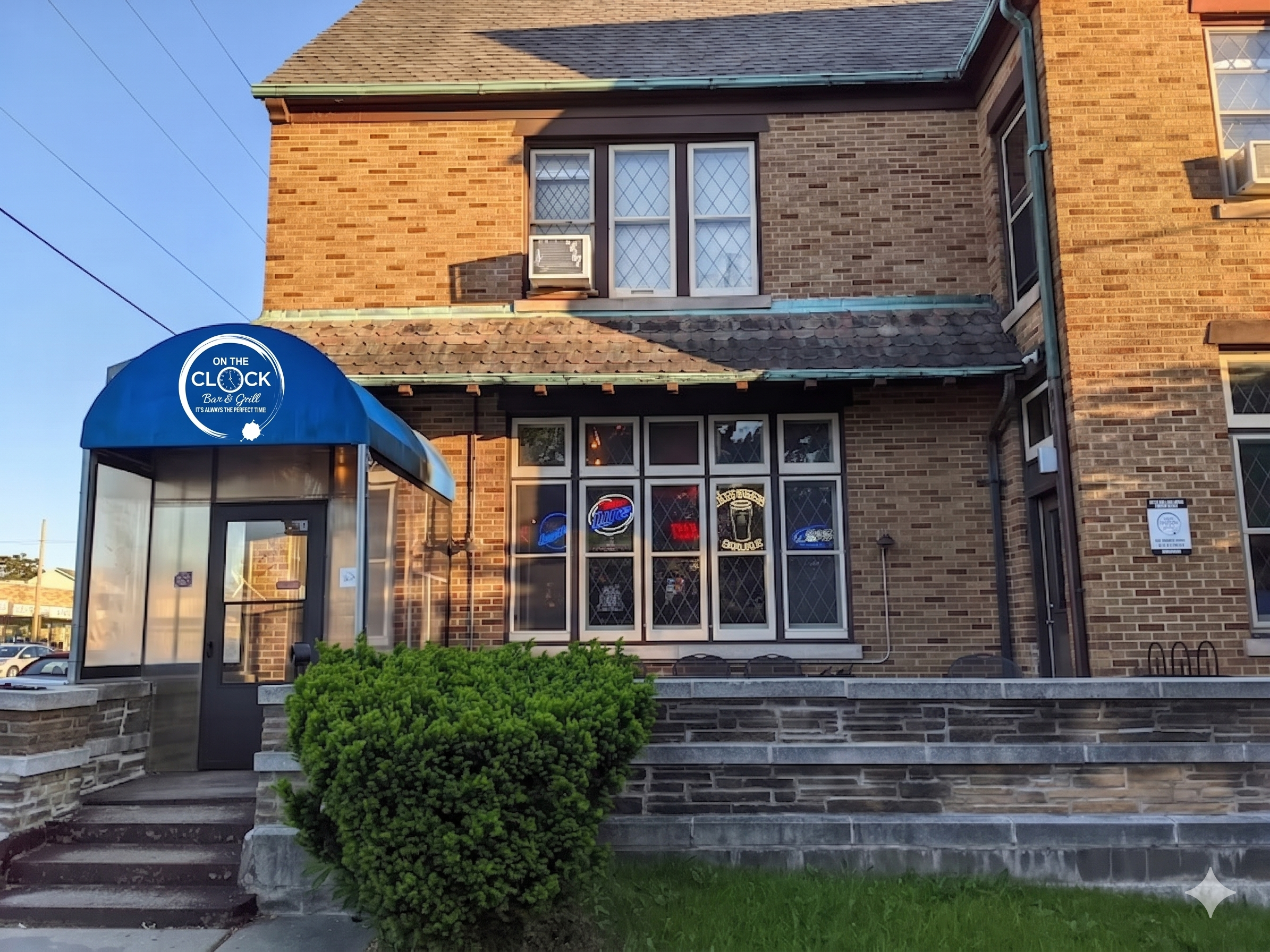 The historic 1903 brick exterior of On The Clock Bar & Grill with its blue awning